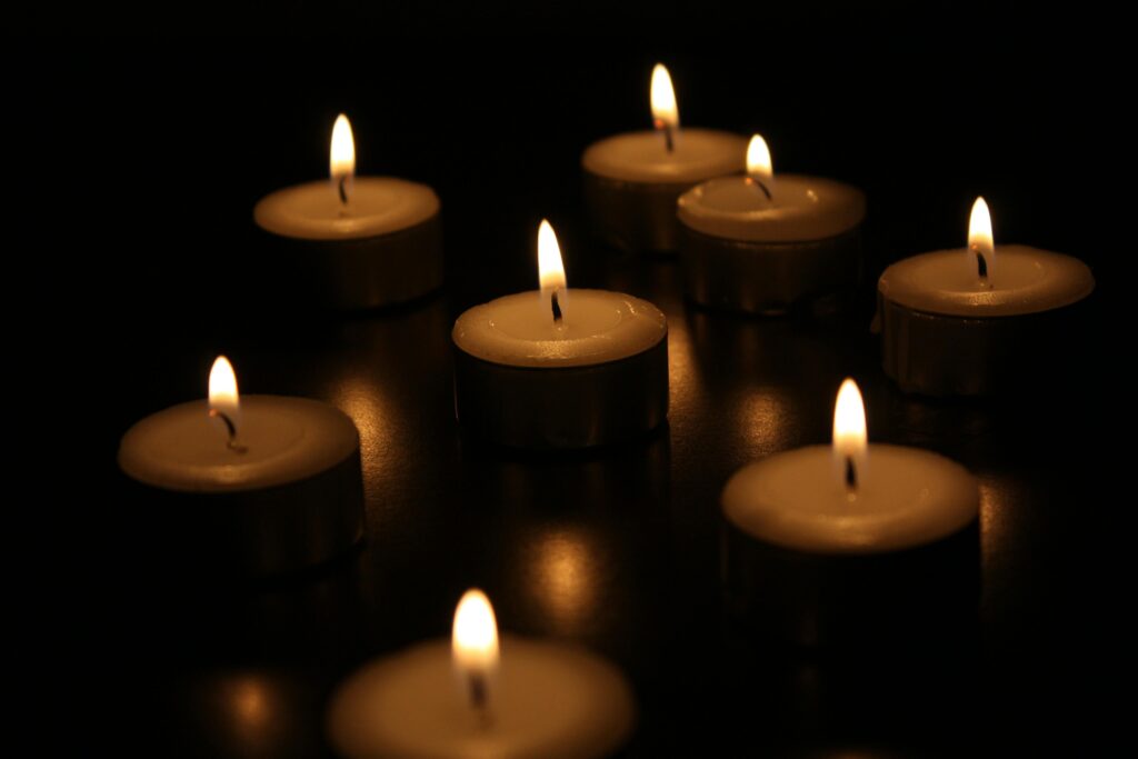 A serene arrangement of burning candles casting a warm glow in the dark.